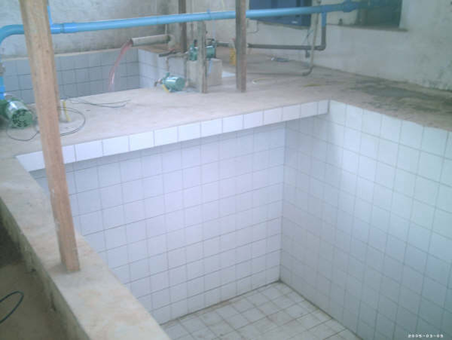 Tanques de solução nutritiva em construção e teste. São dois tanques, um para cada módulo de cultivo, Em segundo plano, montagem provisória da bomba de recalque para testes de vazamentode solução nutritiva. Ao lado, bombas de injeção de solução nutritiva ozonizada, e à direita, vista parcial do gerador de ozonio.